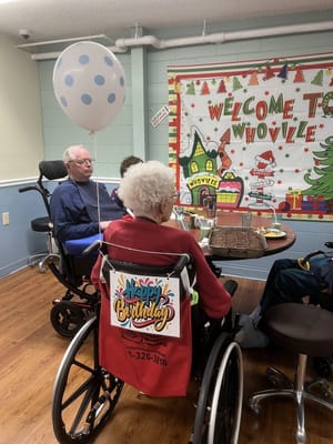 Residents celebrating a birthday with a cake and decorations
