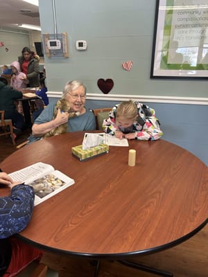 Senior and child engaging in an activity at a table