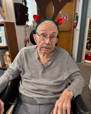 A resident wearing a reindeer headband in a cozy environment