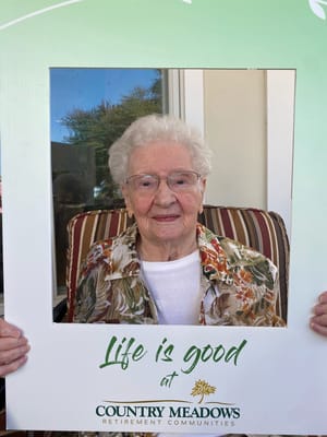 Senior resident holding a photo frame with a positive message