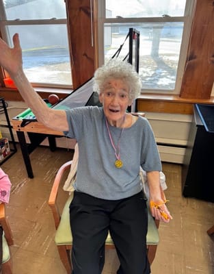 Resident smiling and waving in a common area