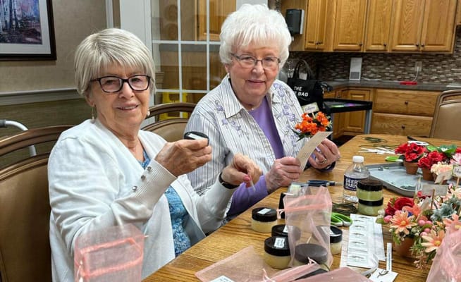 Two residents engaged in a craft activity at a table