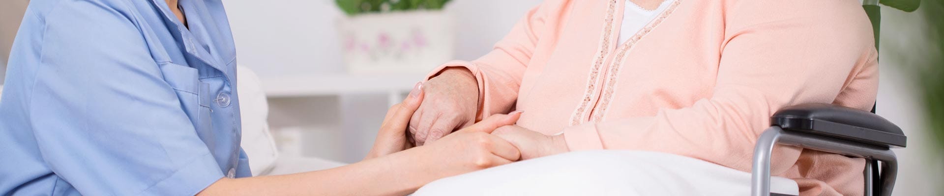 Caregiver holding hands with a resident in a cozy interior
