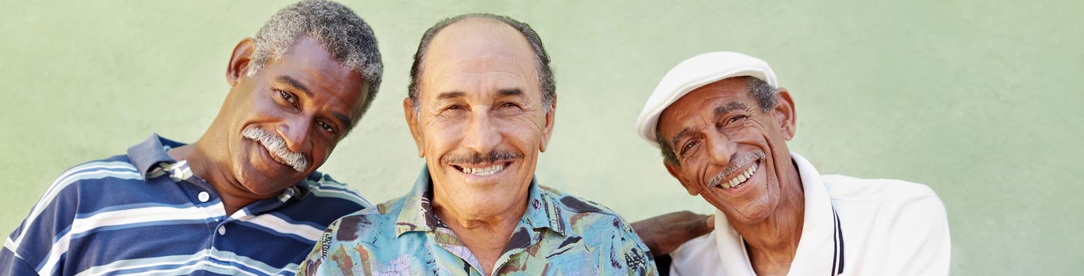 Three smiling elderly men posing together