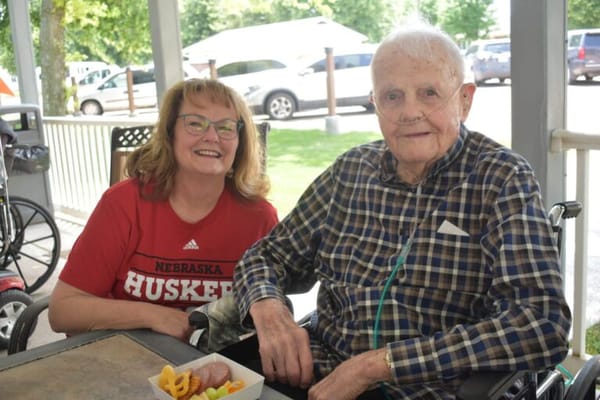 Resident enjoying snacks with staff outdoors