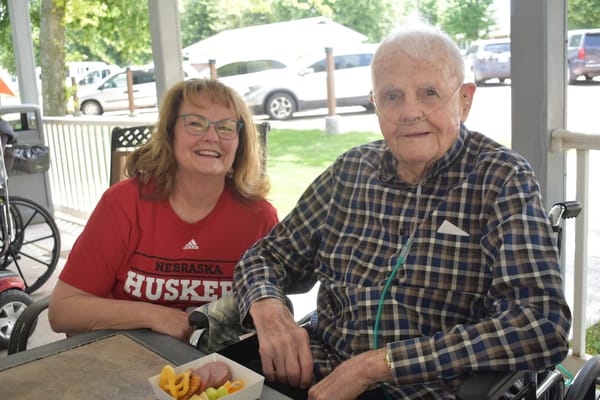 Resident enjoying snacks with staff outdoors