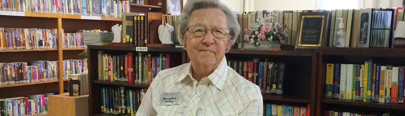 A resident in a library area surrounded by books