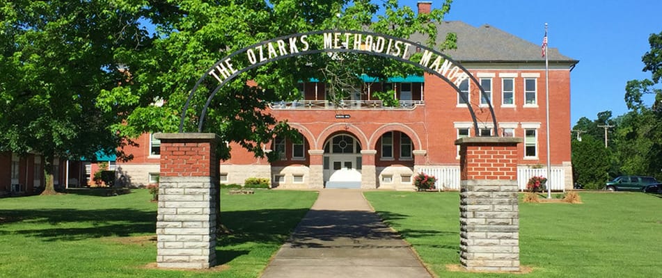 Front view of a senior living facility with greenery