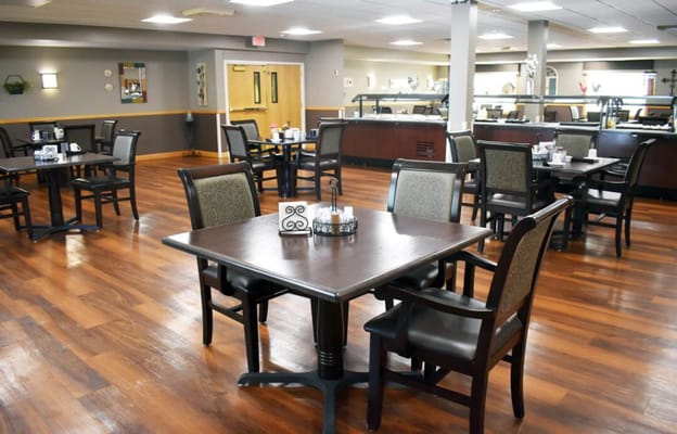 Dining area with tables and chairs in a senior living facility