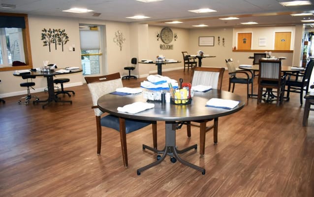 Dining area with tables and chairs set for residents