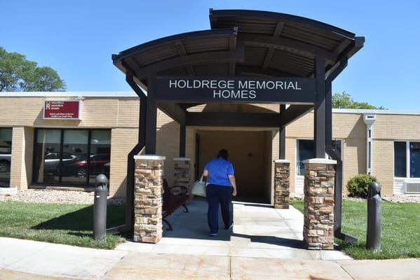 Entrance of Holdrege Memorial Homes with a staff member
