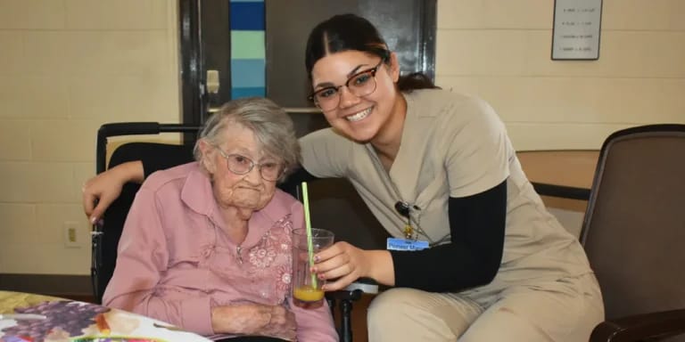 A caregiver posing with a resident in a cozy environment