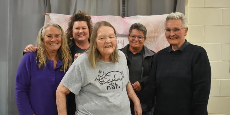 Residents and staff smiling together at a celebration