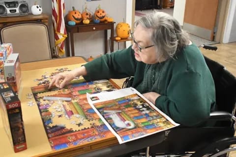 Resident engaged in a puzzle activity in the common area
