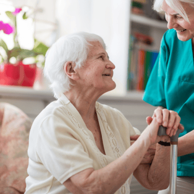 Caregiver assisting a smiling senior resident