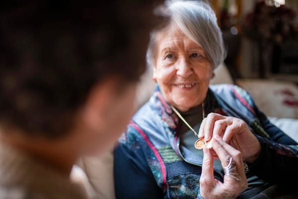 Resident showing a necklace to a staff member