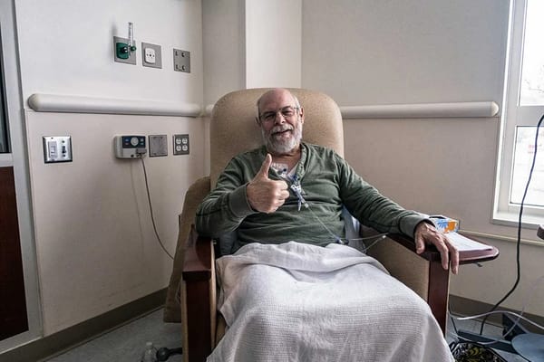 A resident giving a thumbs up in a comfortable chair