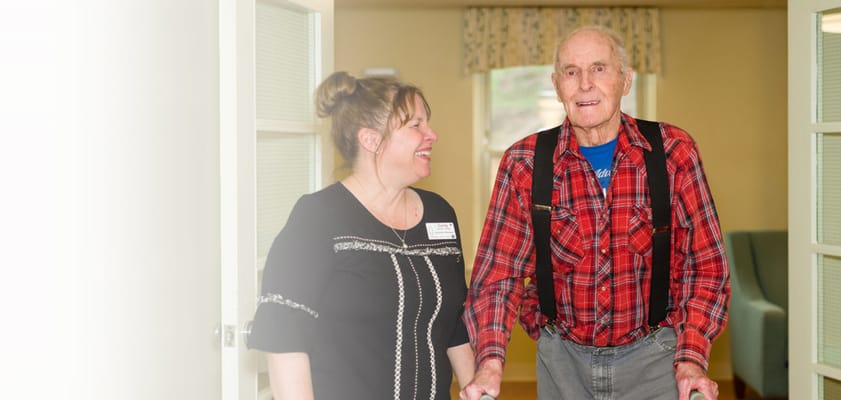 Staff member assisting a resident in a hallway