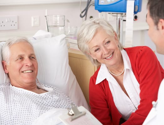Patient smiling with a caregiver and family member