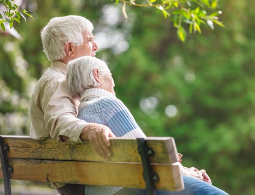 Senior couple sitting together on a park bench