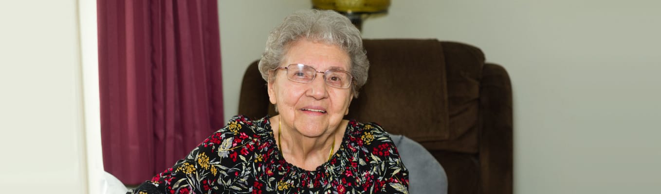 Senior resident smiling in a cozy interior setting