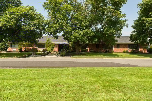 Exterior view of a senior living facility surrounded by trees