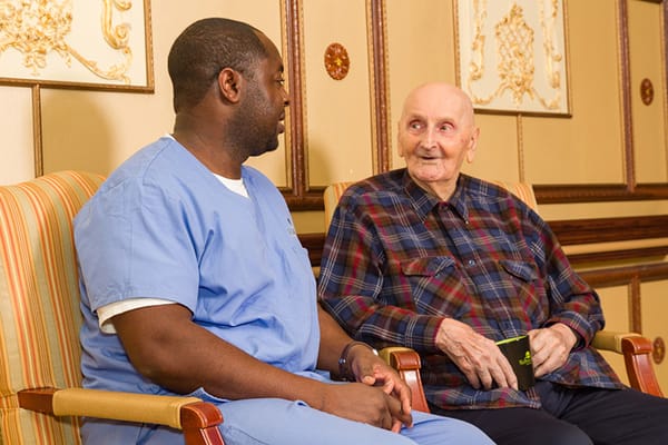 Staff member talking with a resident in a cozy lounge