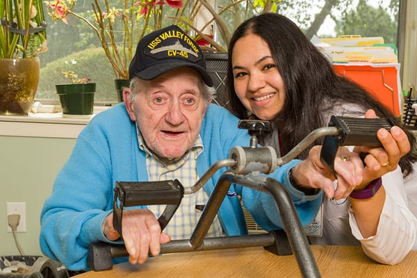 Resident engaging with staff in an activity