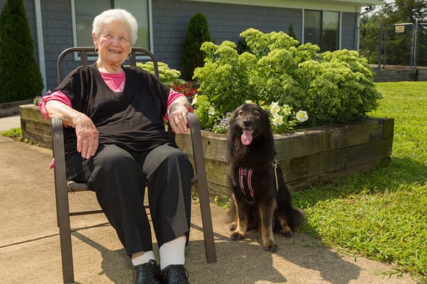 Senior woman sitting outside with a dog