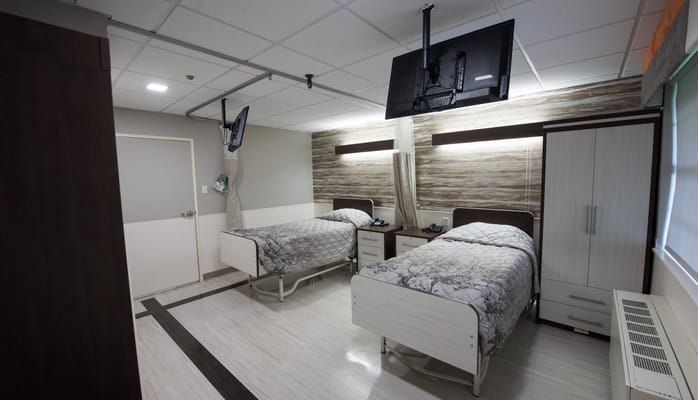 Well-furnished shared room with two beds and TVs