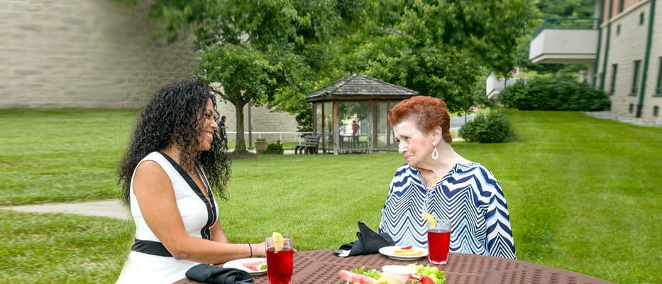 Two women enjoying drinks in a garden area