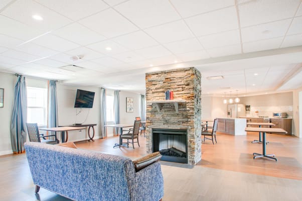 Bright common area with a cozy fireplace and seating