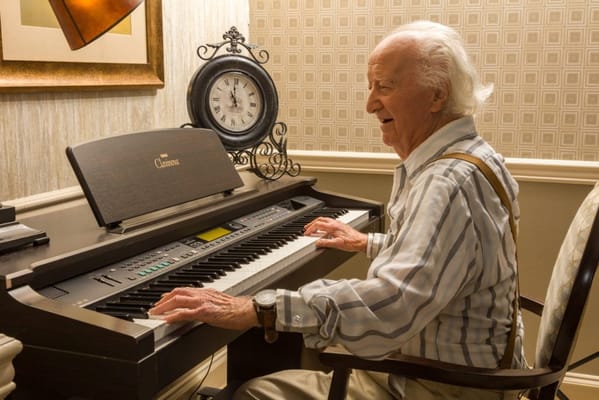 Senior resident playing piano in an indoor setting