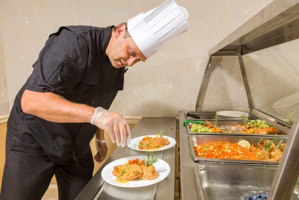 Chef arranging plates in a dining area