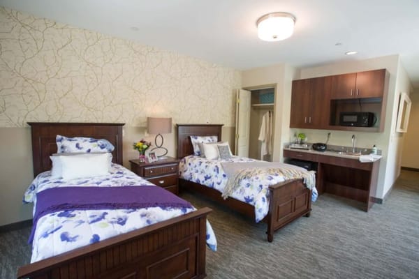 Brightly lit double room with two beds and kitchenette