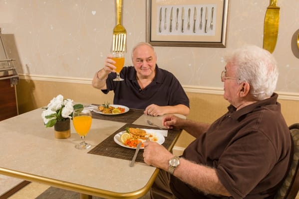 Two residents enjoying a meal together in the dining room