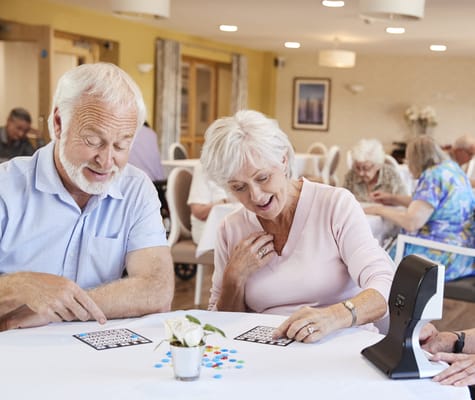 Residents playing bingo in a bright common area