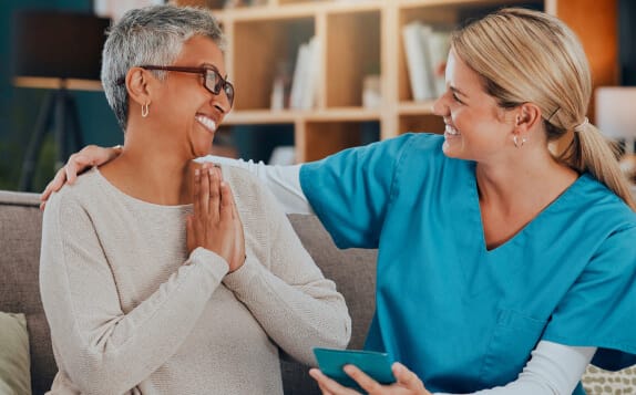 Caregiver smiling with a resident in a cozy lounge