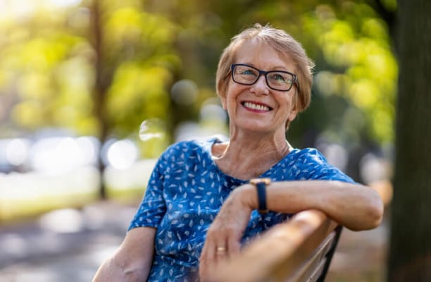 Senior woman smiling outdoors on a bench