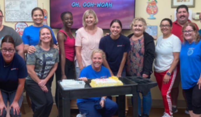 Staff and residents celebrating with a cake