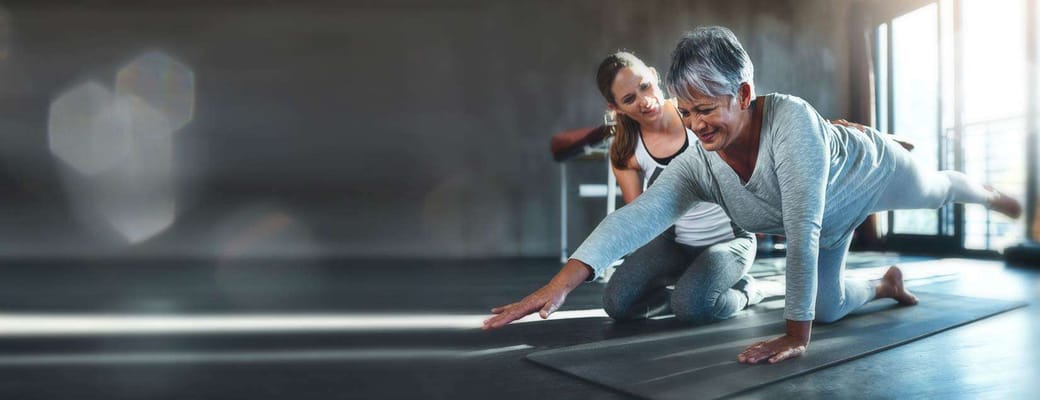 Resident engaging in physical activity with staff assistance