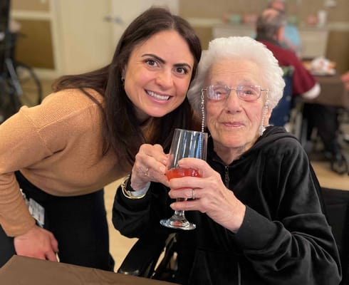 A staff member and a resident enjoying a drink together