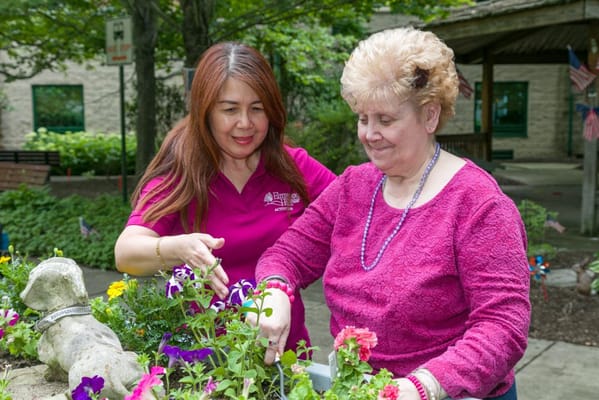 Staff and resident gardening in a vibrant outdoor space
