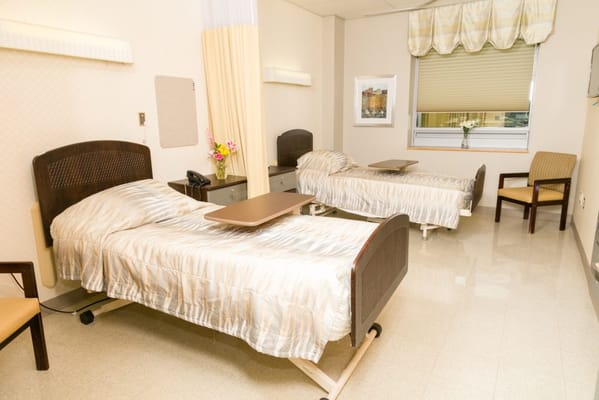 A shared resident room with two beds and a window