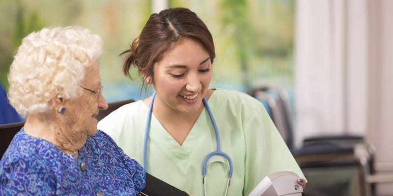 Nurse assisting an elderly resident in a bright room