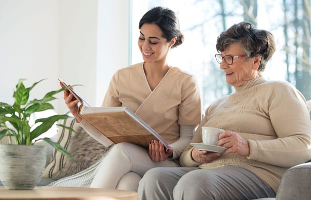 Caretaker reading with a resident in a cozy setting