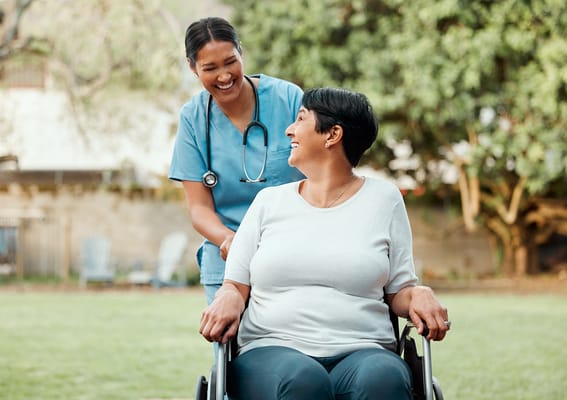 Nurse assisting a resident in a garden area