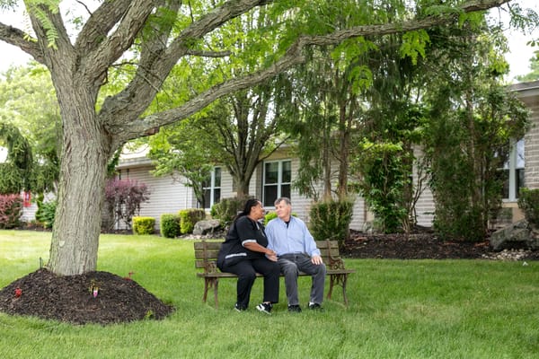 Residents enjoying conversation under a tree in the garden