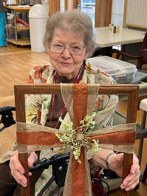 Resident displaying a handmade craft in the common area
