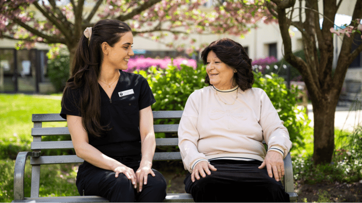 Staff member and resident enjoying a conversation outdoors